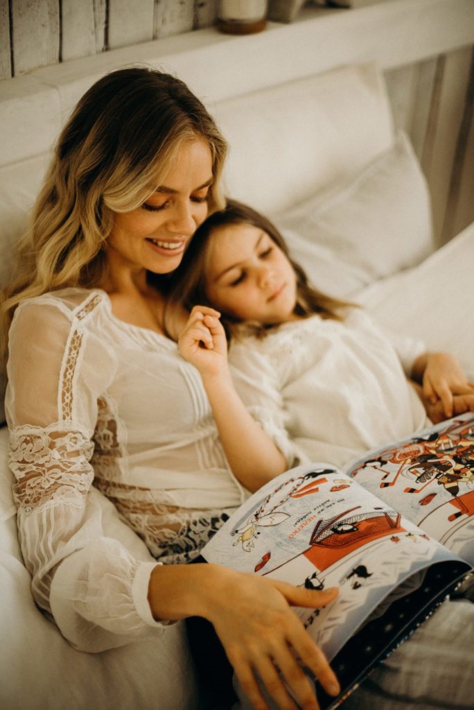 Mother reading young girl bedtime story.