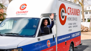 Cranney Home Services technician leaving a job site in branded van waving goodbye
