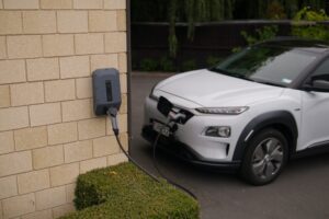 white electric car charging from a home charger