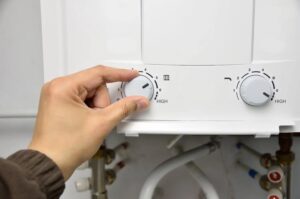 Person adjusting water heater temperature settings