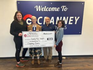 Beverly Main Streets award recipients posing with a large check in front of Cranney sign