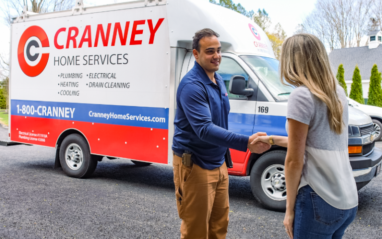 %Focuskw% | Cranney Home Services A Cranney Home Services technician shakes hands with a woman outside her Danvers home, next to a company service van.